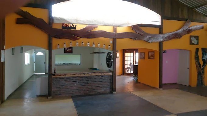 Cantina rústica con barra de ladrillo y vigas de tronco